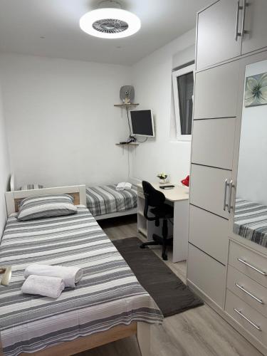 a bedroom with two beds and a desk with a computer at Apartman Sandra in Podstrana
