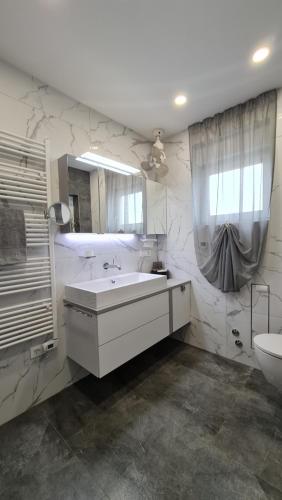 a white bathroom with a sink and a mirror at MEERBLICK DUPLEX POOL-VILLA REGIRMA DELUXE bis 8 Personen in Vodice