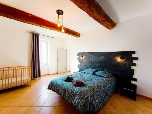 une chambre avec un lit avec une couette bleue dans l'établissement Entre montagne et lavande - Maison Provençale, à Saint-Étienne-les-Orgues