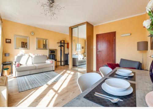 una sala de estar con una mesa y un sofá en Apartamenty Zachód Słońca Mi Casa Holidays, en Mielno
