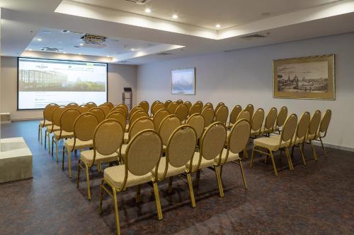 a conference room with chairs and a projection screen at Premier Hotel Dnister in Lviv