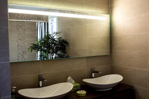 une salle de bain avec deux lavabos et un miroir dans l'établissement Spacious Duplex Pantin, near Paris, à Pantin