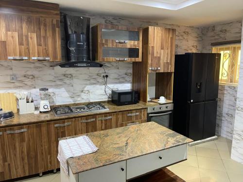 a kitchen with a black refrigerator and a counter at Global Premium Apartments in Abuja