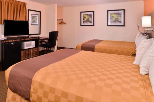 a hotel room with two beds and a flat screen tv at Americas Best Value Inn Ponca City in Ponca City