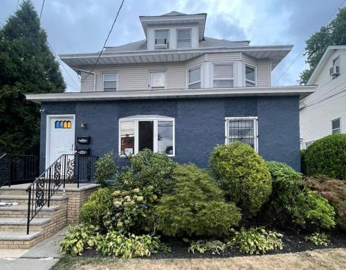 a blue house with a white at Cozy 2BR Basement Apartment with Private Entry & Parking in Elizabeth, NJ in Elizabeth