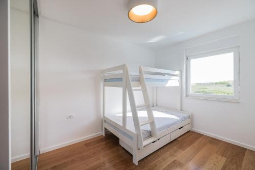 a bedroom with a bunk bed and a window at VILLA VISTA, Jacuzzi, Pool in Privlaka