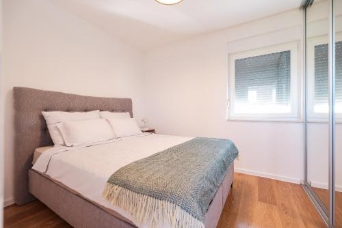 a bedroom with a large bed with a window at VILLA VISTA, Jacuzzi, Pool in Privlaka
