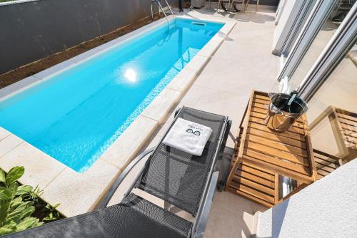 an overhead view of a swimming pool with a table and a chair at VILLA VISTA, Jacuzzi, Pool in Privlaka