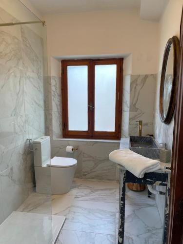 a bathroom with a toilet and a window at Casa del Gelso in Vigneta