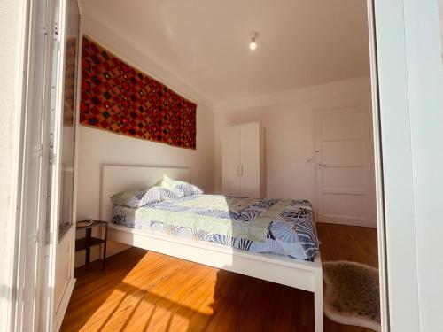 a bedroom with a bed and a painting on the wall at Maharaja - Grande Maison & Terrasse Plage in Isigny-sur-Mer
