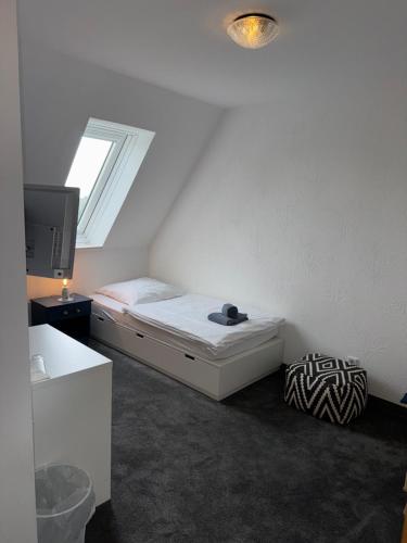 a small bedroom with a bed and a tv at Hotel Everswinkel in Everswinkel