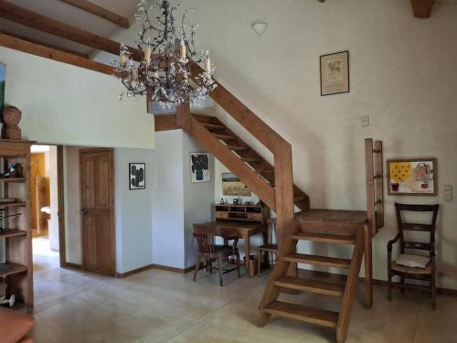 una scala in un soggiorno con tavolo e lampadario a braccio di La Maison perchée - Mas de Rousseau a Eyragues