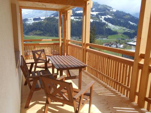 a wooden porch with two chairs and a wooden table at Ferienwohnung Brugger in Zellberg