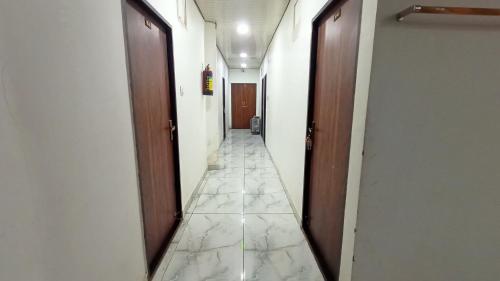 a hallway with two doors and a tile floor at Hotel Anmol Palace in Lashkar