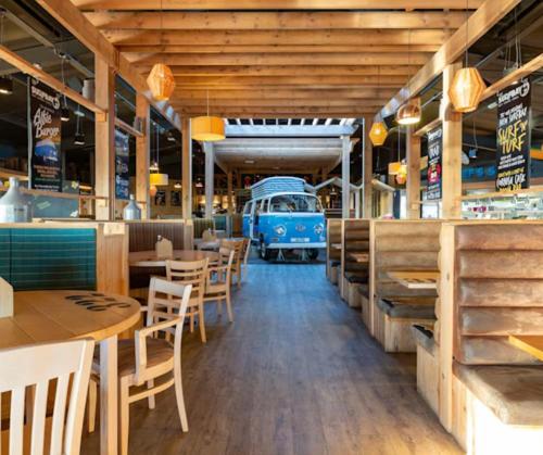 an empty restaurant with an old van in the background at Dune Breeze-Haven Perran Sands Holiday Park in Perranporth