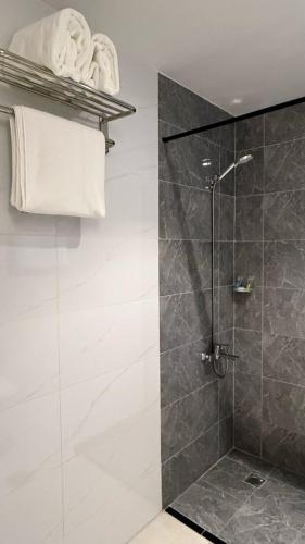 a bathroom with a shower with a glass door at فندق جادة الغمامة in Medina