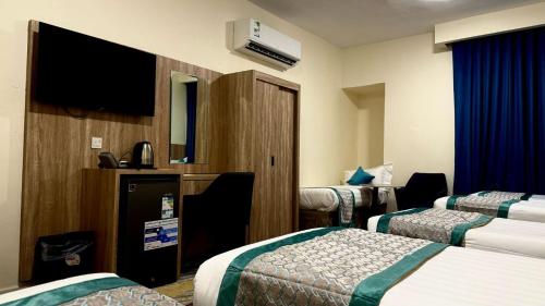 a hotel room with two beds and a flat screen tv at فندق جادة الغمامة in Medina