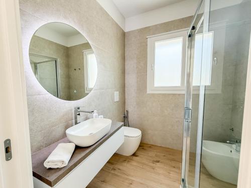 un baño con lavabo y espejo en TWINSANDBI Apartments B, en Taranto