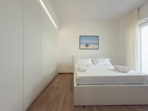 Un dormitorio blanco con una cama y una ventana. en TWINSANDBI Apartments B, en Taranto