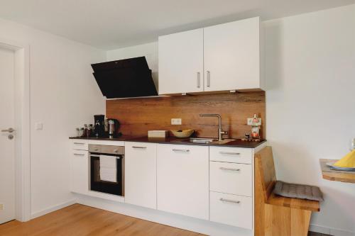 a kitchen with white cabinets and a sink at Ferienwohnung Staffe in Bonndorf im Schwarzwald