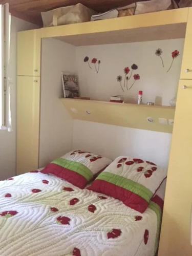 ein Schlafzimmer mit einem Bett mit Blumen darauf in der Unterkunft Chalet accueillant avec vue sur le lac in Estang