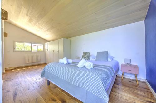 une chambre avec un lit avec une couette bleue et blanche dans l'établissement Les Coquelicots du Bassin - avec piscine privée, à Gujan-Mestras