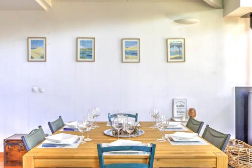 une salle à manger avec une grande table et des chaises en bois dans l'établissement Les Coquelicots du Bassin - avec piscine privée, à Gujan-Mestras
