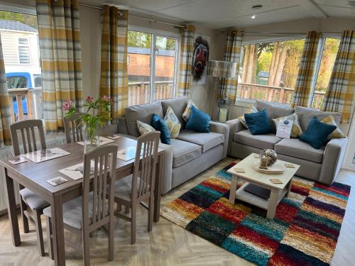 a living room with a couch and a table and chairs at Travellers Rest Retreat in Oxnam