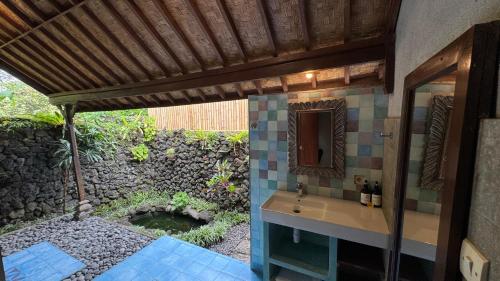 a bathroom with a sink and a mirror at Lihat Sawah Cottage in Sidemen