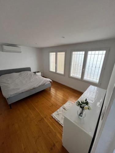 une chambre avec un lit, une table et des fenêtres dans l'établissement Appartement au coeur de Marseille, à Marseille