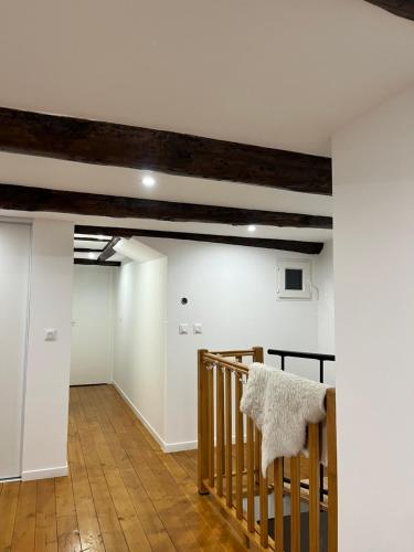 un couloir avec des murs blancs et un escalier en bois dans l'établissement Appartement au coeur de Marseille, à Marseille