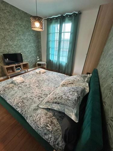 un grand lit dans une chambre avec une fenêtre dans l'établissement Le Nid de la Grotte, à Lourdes