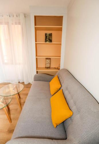 - un canapé avec deux oreillers jaunes dans le salon dans l'établissement Yellow flower heart of Grasse, à Grasse