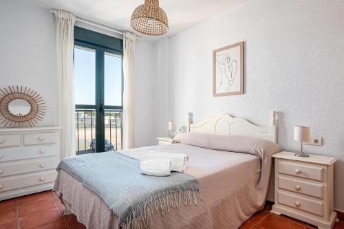 a white bedroom with a bed and a window at aldea 3 4 1ºB in Novo Sancti Petri