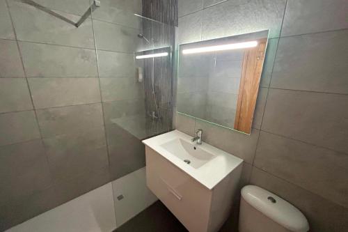 a bathroom with a sink and a toilet and a mirror at aldea 3 4 1ºB in Novo Sancti Petri