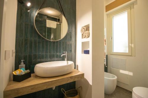 a bathroom with a sink and a mirror and a tub at Le Case di PA in Anzio