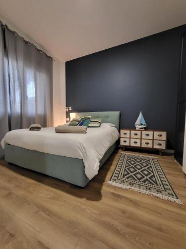 a bedroom with a large bed and a rug at Le Case di PA in Anzio