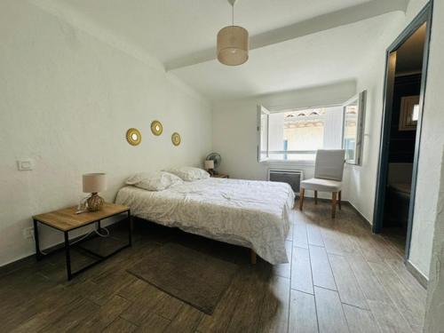 une chambre avec un lit, une table et une chaise dans l'établissement Grand T2 50m2 Narbonne centre, vue sur cathédrale, à Narbonne