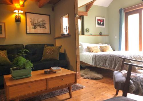 a living room with a couch and a bed at Eco-friendly Cornish sanctuary in Penzance