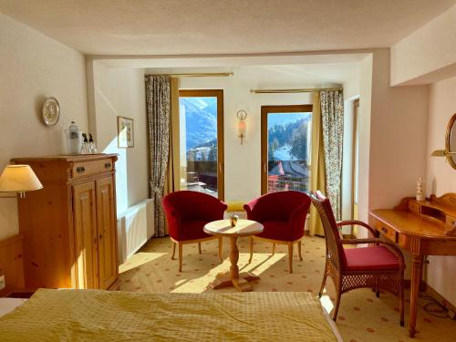 a bedroom with a table and two chairs and a desk at Hotel Garni Zerzer in Serfaus