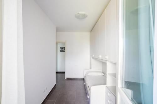 a room with white walls and a row of beds at Lovely Tiresia Apartment in Sperlonga