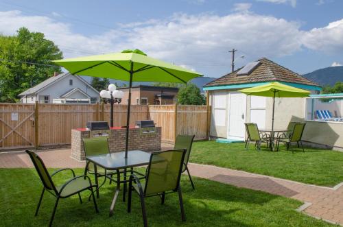 a patio with a table and chairs and umbrellas at Tiki Shores Inn & Suites in Penticton
