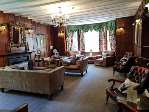 a living room with couches and a chandelier at Passford House Hotel in Lymington