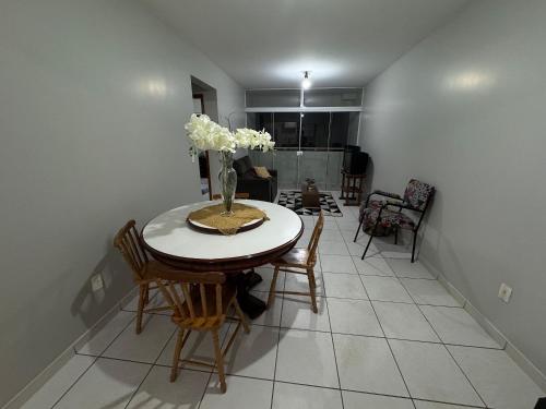a dining room table with chairs and a vase of flowers at Apartamento Aconchegante em Localização Central in Toledo