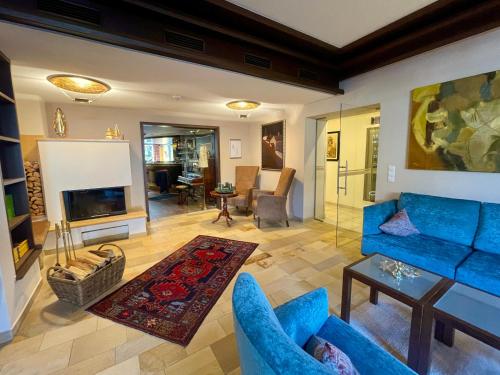 a living room with blue furniture and a fireplace at Hotel Garni Zerzer in Serfaus