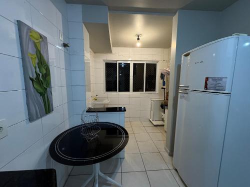 a small kitchen with a table and a refrigerator at Apartamento Aconchegante em Localização Central in Toledo