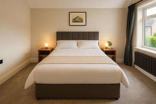 a bedroom with a large bed with two night stands at 4 Bedroom Spacious House in Cardiff in Cardiff