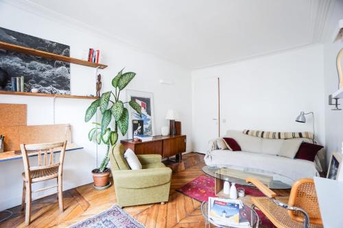 un salon avec un canapé et une table dans l'établissement Beautiful Design Apt In Paris Near The Louvre, à Paris