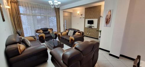 a living room with leather furniture and a television at Gemütliches Zimmer in guter Lage in Addis Ababa