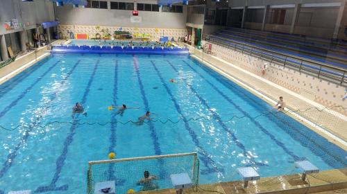a large swimming pool with people in the water at Orion Guest Villa Casais in Lousada